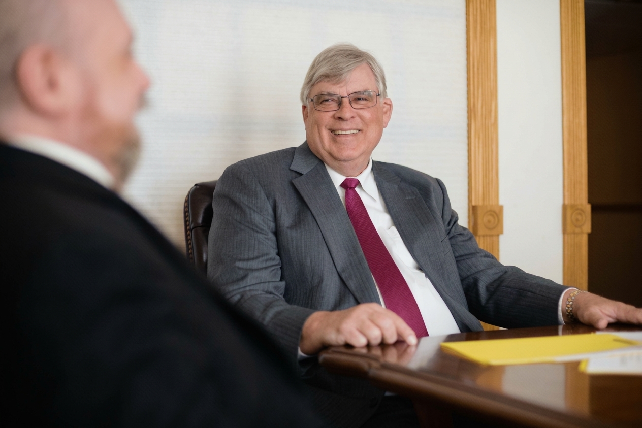 George K. Rahdert (1950–2025) meeting with a client at the conference table